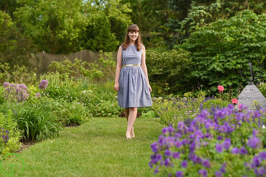 A high school senior strolls through the lush gardens at Matthaei Botanical Gardens for her senior session