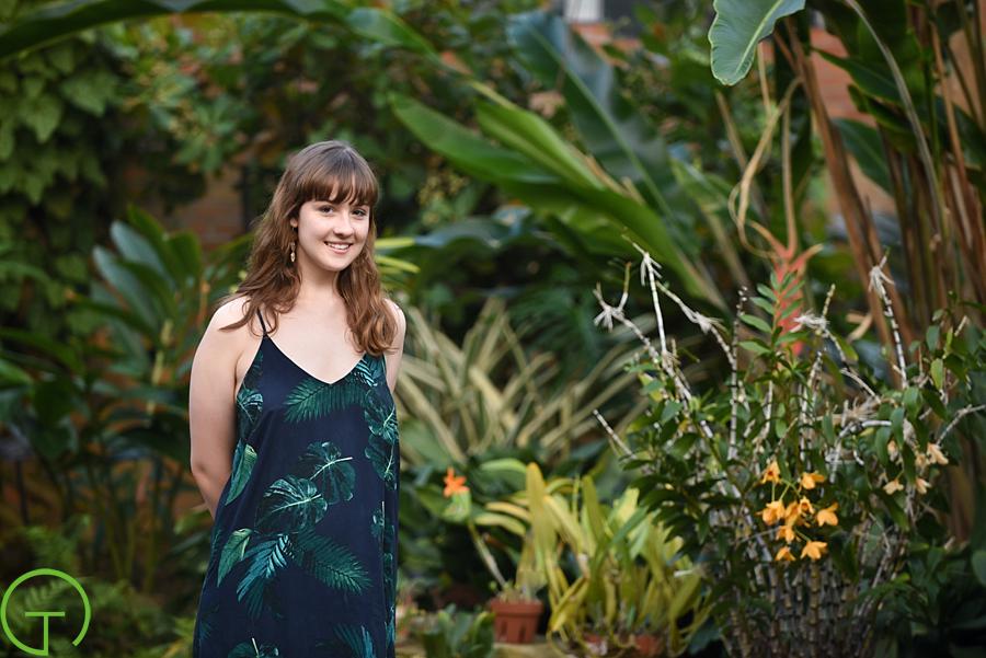 A high school senior poses near tropical plants at Matthaei Botanical Gardens in ann arbor